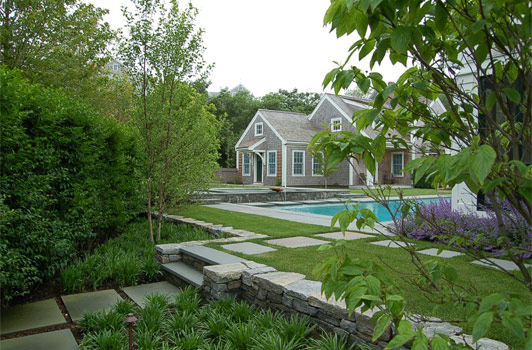 title:Walking by the guest room wing of the main house, one discovers the pool area and the guest house at the back.