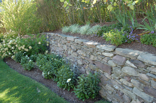 title:More stone walls were integrated elsewhere on the property to facilitate the grading needed to create a large play area for the children.