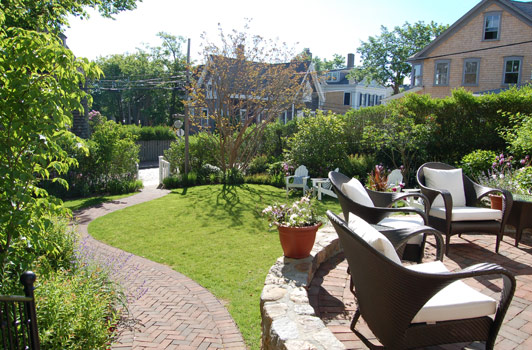 title:The main garden path bisects the lawn area below. This path aids in creating multiple seating sections in the garden.